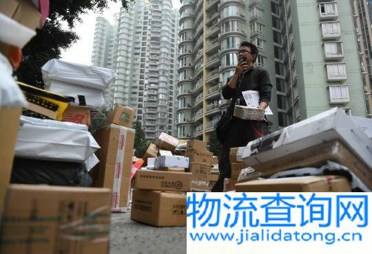 资料图:快递员正在与顾客联系收取快递。 陈超 摄